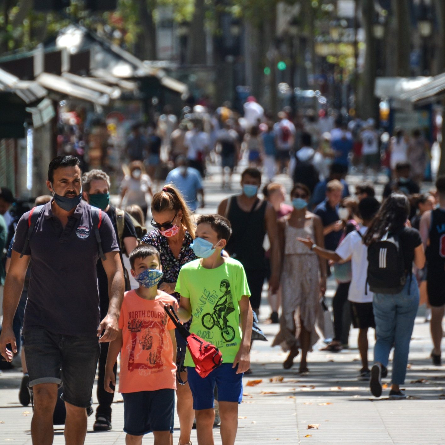 Barcelona, Spain, August 8, 2020: Family walking in La Rambla wearing protective medical masks for prevent virus Covid-19 in Barcelona, Spain, Europe
